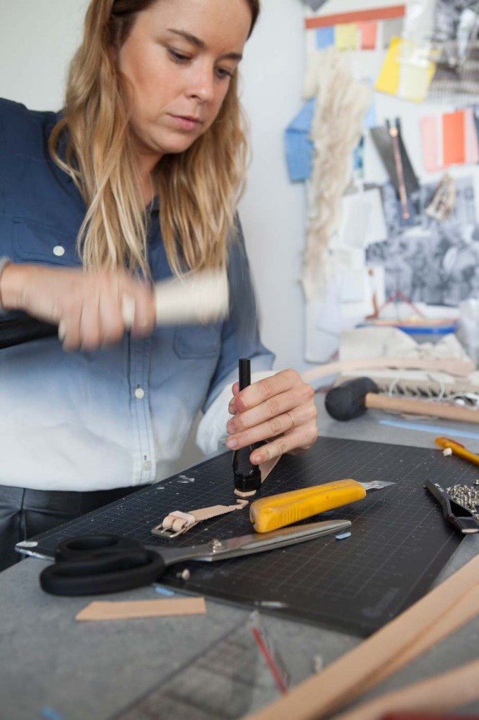 Marina Hoermanseder stanzt Leder mit einem Hammer - Produktion der Showroomkollektion des Fetisch-Mode-Labels. Atelier in Berlin. Fotodokumentation für WWD