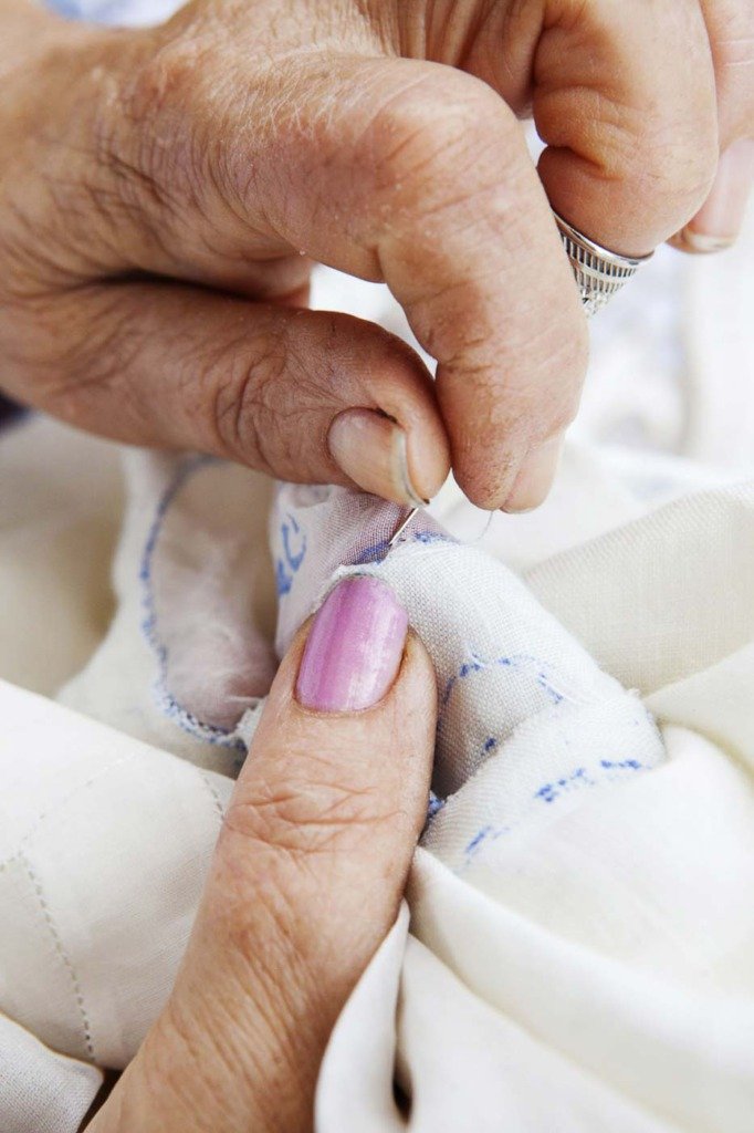 Madeira Stickerei Produktionsprozess, das eigentliche Sticken übernehmen Frauen auf der ganzen Insel in Heimarbeit. Close-Up auf Hände einer älteren Näherin